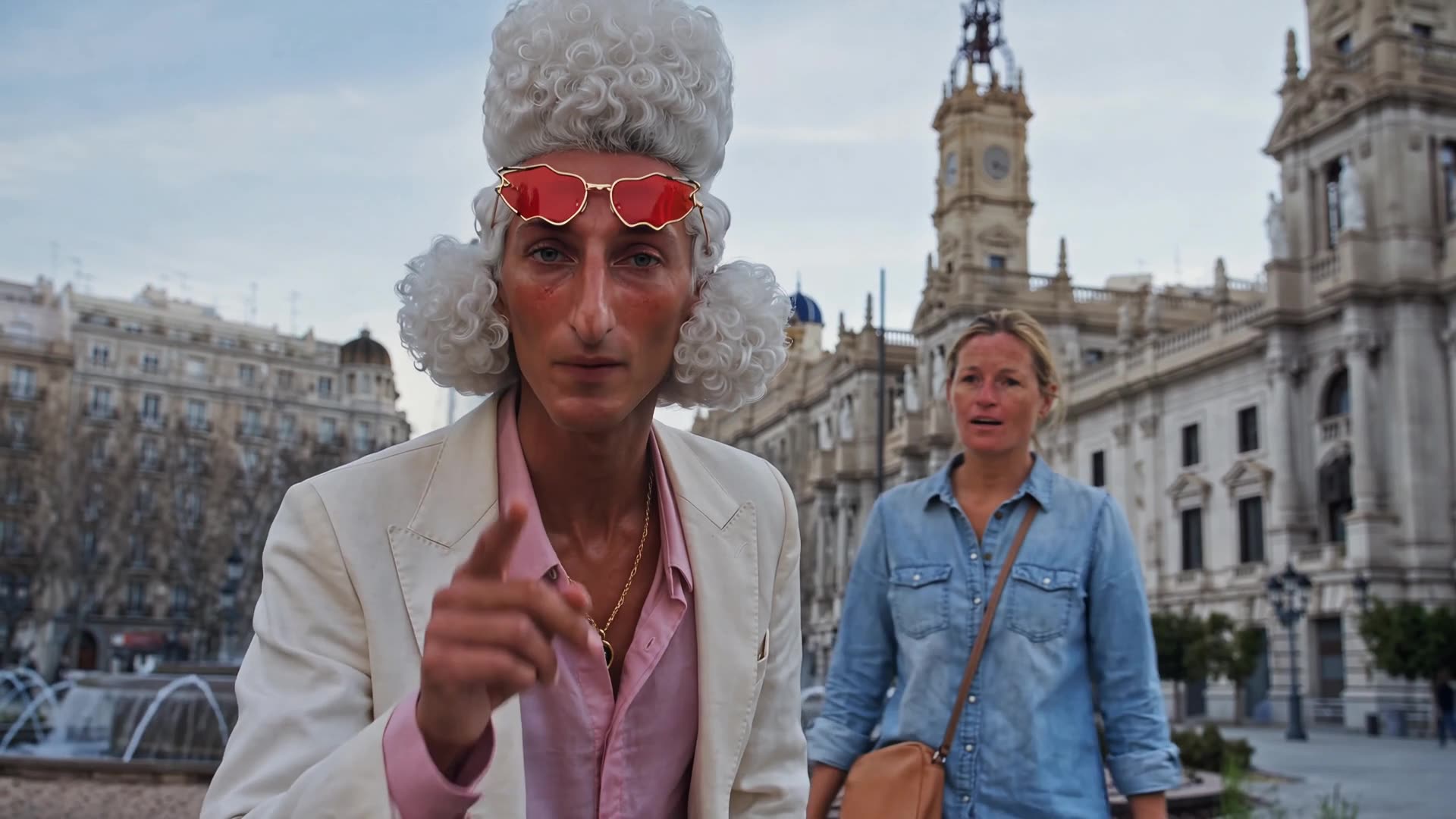 Episodio 5: el Caniche señala a cámara con Hannah frente al Ayuntamiento de Valencia